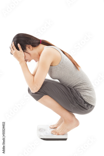 Photo: surprised woman looking at weight scales surprised woman looking at weight scales