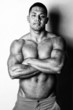 Handsome shirtless man is posing on bright background