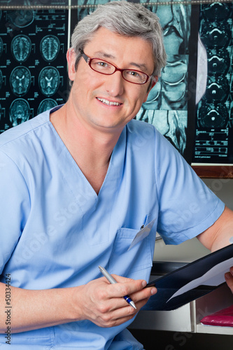 Photo: Male Doctor Holding Clipboard Male Doctor Holding Clipboard