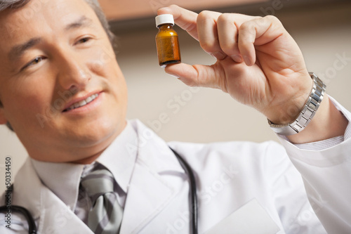 Photo: Doctor Looking At Medicine Bottle Doctor Looking At Medicine Bottle