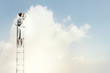 Businesswoman standing on ladder