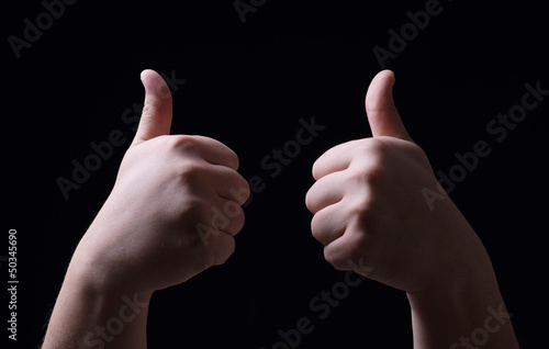 Photo: Thumb up on black background Thumb up on black background