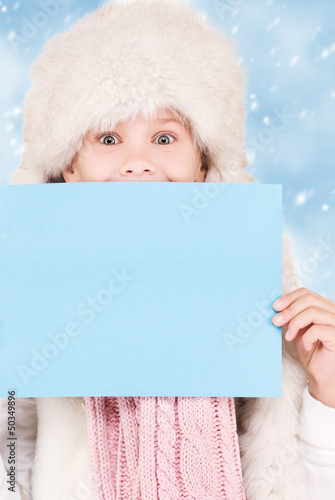 Photo: girl in winter hat with blank board girl in winter hat with blank board