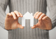man holding paper house