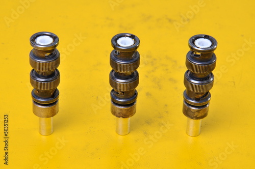 Photo: Used BNC connectors on yellow surface of device Used BNC connectors on yellow surface of device