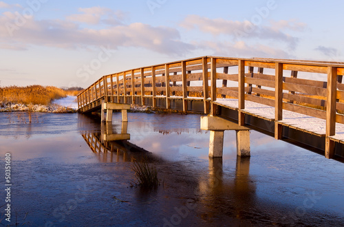 Photo: wooden bridge through frozen river wooden bridge through frozen river