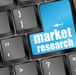 Blue key with market research text on laptop keyboard