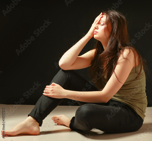 Photo: Depressed woman sitting on floor with eyes closed Depressed woman sitting on floor with eyes closed