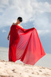 Foto: naked woman on a beach with red fabric naked woman on a beach with red fabric