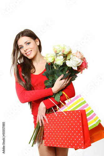 Photo: Lovely girl with shopping bags and roses on a white background Lovely girl with shopping bags and roses on a white background