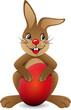 Brauner Osterhase mit rotem Ei