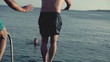 Young men jumping, swimming in the sea, slow motion shot at 120f