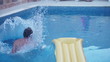 Young man jumping in the swimming pool, slow motion shot at 240f