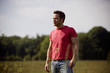 A young man standing in a field in summertime