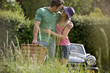 A young couple carrying a picnic basket in summertime