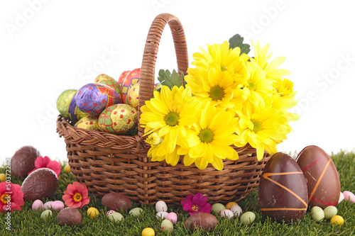 Photo: easter eggs in wicker basket with flowers easter eggs in wicker basket with flowers