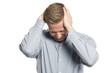 Miserable businessman with hands at head showing grief.
