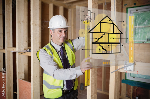 Photo: Architect using spirit level and looking at hologram interface Architect using spirit level and looking at hologram interface