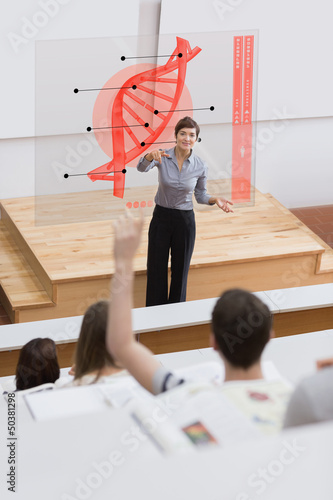 Photo: Teacher in front of futuristic interface pointing college studen Teacher in front of futuristic interface pointing college studen