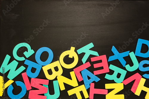 Photo: Alphabet magnets in a jumble on blackboard Alphabet magnets in a jumble on blackboard