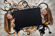 Girls pointing to black copy space on artistic swirl design back