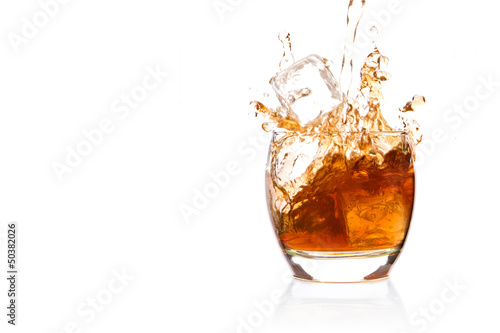 Photo: Ice cube falling into glass of whisky Ice cube falling into glass of whisky