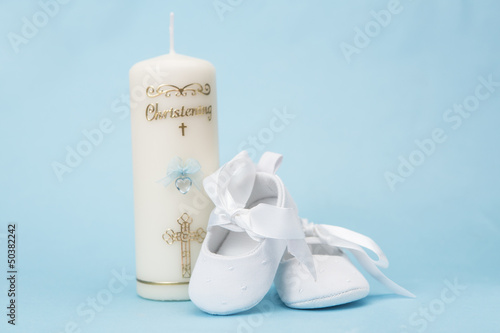 Photo: Christening candle for a boy with white baby booties Christening candle for a boy with white baby booties
