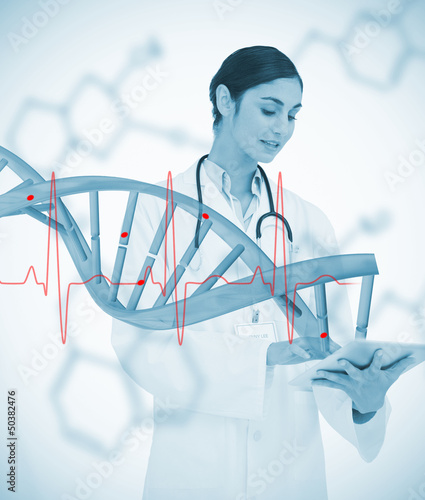 Photo: Doctor using tablet pc with graphic dna helix and ECG line Doctor using tablet pc with graphic dna helix and ECG line