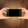 Wooden Background With Hands Holding Phone