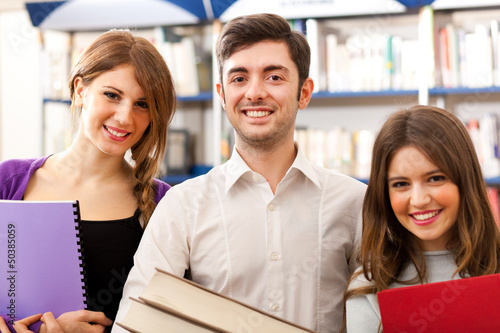 Photo: Smiling young students in a library Smiling young students in a library