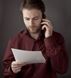 Office worker reading documents during phone conversation