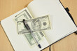 open book in which the money is and pen