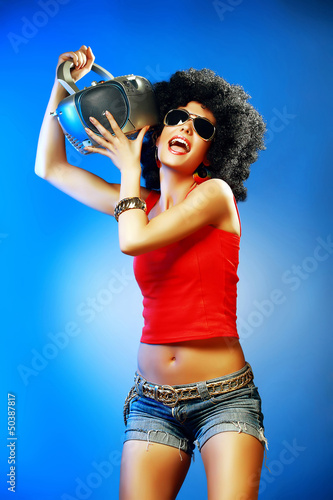 Photo: Happy tanned woman enjoying music holding tape recorder. Happy tanned woman enjoying music holding tape recorder.