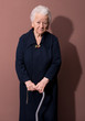 Old woman with a cane on brown background