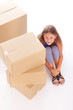 Photo: Cute little girl is hiding behind boxes Cute little girl is hiding behind boxes