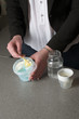 Young mother's hands preparing powdered milk drink for her baby