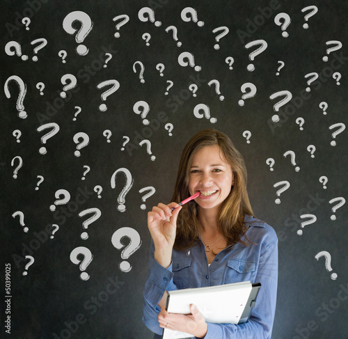 Photo: Thinking business woman with chalk question marks Thinking business woman with chalk question marks