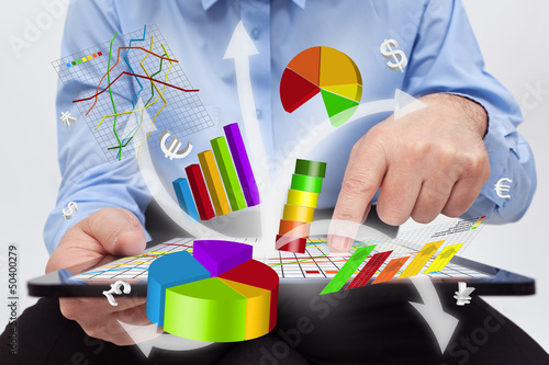 Photo: Businessman working on tablet computer - producing charts Businessman working on tablet computer - producing charts