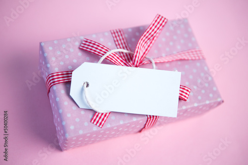 Photo: Pink gift wrapped box with blank tag Pink gift wrapped box with blank tag