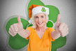 Girl in orange t-shirt giving thumbs up on shamrock background