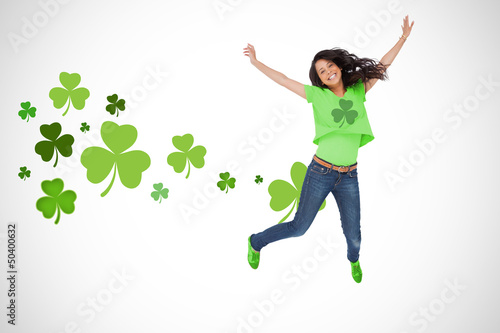 Photo: Girl wearing green shamrock t-shirt jumping for joy Girl wearing green shamrock t-shirt jumping for joy