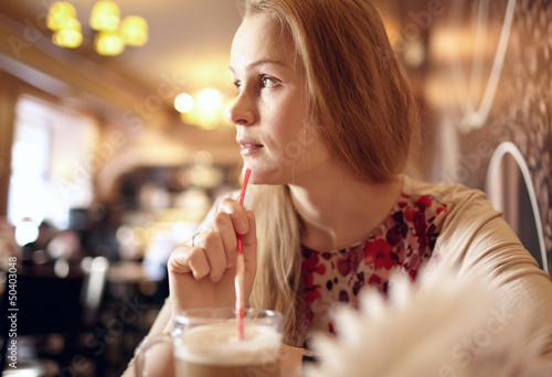 Photo: Girl is looking through the window in cafe. Girl is looking through the window in cafe.