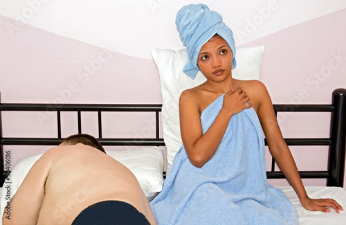 Photo: woman resting in bed with sleeping man woman resting in bed with sleeping man