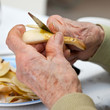 Personne âgée épluchant une poire
