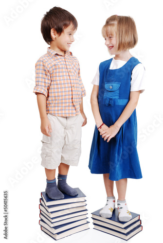 Photo: Two kids standing on pile of books Two kids standing on pile of books