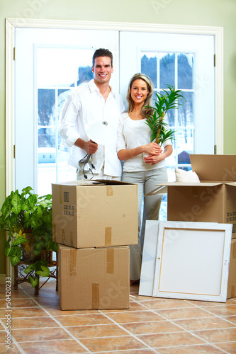 Photo: Happy couple moving in a new house. Happy couple moving in a new house.