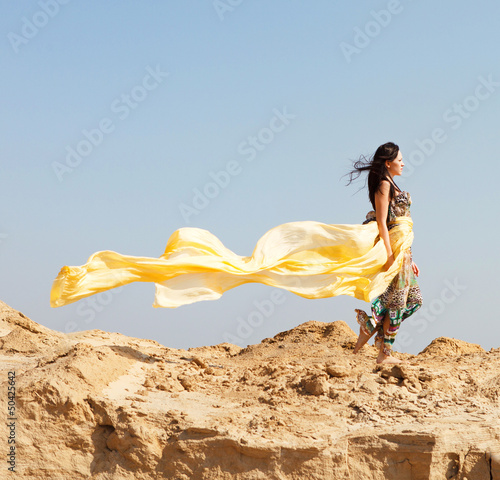 Photo: Young woman walking in a desert Young woman walking in a desert