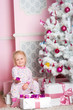 The girl at the Christmas fir-tree with gifts