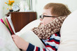 Sick little boy lying in bed with thermometer