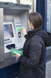 Frau hebt Geld am Geldautomaten ab